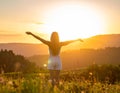 Happy woman standing with her back on sunset in nature iwith ope. Happy woman standin Royalty Free Stock Photo