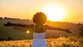 Happy woman standing with her back on sunset in nature iwith ope. Happy woman standin Royalty Free Stock Photo