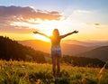 Happy woman standing with her back on sunset in nature iwith ope. Happy woman standin Royalty Free Stock Photo