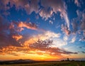 Dramatic sunset over a rural landscape with vibrant clouds Royalty Free Stock Photo