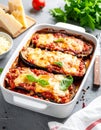 Eggplant casserole with cheese and tomato sauce in a white baking dish on a gray conc Royalty Free Stock Photo