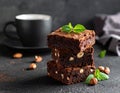 A stack of chocolate brownies with mint and hazelnuts on a dark background with cup Royalty Free Stock Photo