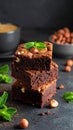 A stack of chocolate brownies with mint and hazelnuts on a dark background with cup Royalty Free Stock Photo