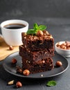 A stack of chocolate brownies with mint and hazelnuts on a dark background with cup Royalty Free Stock Photo