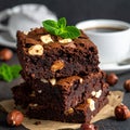 A stack of chocolate brownies with mint and hazelnuts on a dark background with cup Royalty Free Stock Photo