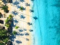 Aerial view of sandy beach, shadows of palms, blue sea at sunset Royalty Free Stock Photo