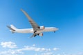 Airplane passenger plane with landing gear extended flying on blue sky, side view Royalty Free Stock Photo