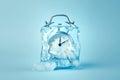 Alarm clock in ice cube, frozen time. Stopping the time concept, freeze time. Royalty Free Stock Photo