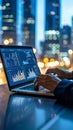 Analyst working on laptop with stock market data at night in city Royalty Free Stock Photo