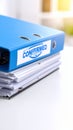 Blue binder with confirmed stamp on a stack of documents on white table Royalty Free Stock Photo