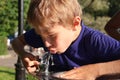 Boy drinks water from street tap on hot summer day. To quench his thirst. Close-up