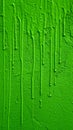 Bright green paint dripping down a rough textured wall Royalty Free Stock Photo