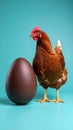 Brown hen standing next to large chocolate Easter egg on turquoise background Royalty Free Stock Photo