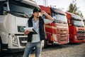Business things, with notepad. Truck driver is near the transport outdoors. Royalty Free Stock Photo
