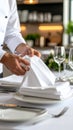 Chef setting a formal dining table with white linen napkins and plates in a restaurant. Royalty Free Stock Photo