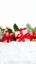Christmas presents with red ribbons and festive decorations in snow on a white background with copy space Royalty Free Stock Photo