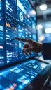 Close up of hand touching glowing digital screen displaying data charts and graphs in a modern control room Royalty Free Stock Photo