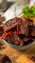 Close-up of Homemade Beef Jerky in Bowl on Wood with Herbs Royalty Free Stock Photo
