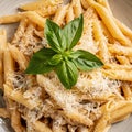 Close up penne pasta in tomatoes, cheese and basil in white plate