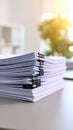 Close-up of a stack of paper documents held together with black binder clips on a desk. Royalty Free Stock Photo