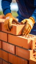 Construction worker laying bricks building a wall with gloved hands close up Royalty Free Stock Photo