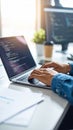 Developer typing code on a laptop computer keyboard in a bright modern office workspace Royalty Free Stock Photo