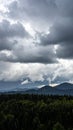 Dramatic storm clouds over forest and mountain range with rain Royalty Free Stock Photo