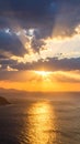 Dramatic sunset over the ocean with sun rays breaking through the clouds Royalty Free Stock Photo