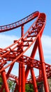 Dynamic Red Roller Coaster Track Arching Upwards Against Bright Blue Sky Amusement Park Adventure Royalty Free Stock Photo