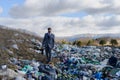 Businessman walking across on landfill, large pile of waste. Consumerism versus pollution concept. Corporate social Royalty Free Stock Photo