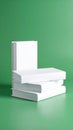 Four blank white books stacked on a vibrant green background with one standing upright Royalty Free Stock Photo