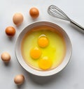Fresh cracked eggs in ceramic bowl flour, shells, and whole brown eggs placed on clean white table Royalty Free Stock Photo