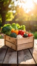 Fresh vegetables in wooden crate on rustic table with blurred garden background Royalty Free Stock Photo