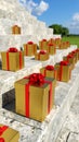 Golden Gift Boxes Lined Up on Stone Steps Outdoors Royalty Free Stock Photo