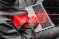 Hacker in a hoodie holds a laptop with a red HACKED warning and binary code overlay, symbolizing a cybersecurity breach
