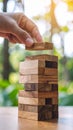 Hand Placing Block on Wooden Tower Game Focus on Challenge and Strategy Royalty Free Stock Photo