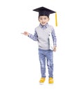 Happy Asian school kid graduate in graduation cap and hand pointing to copy space Royalty Free Stock Photo