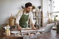 Man rolls clay with rolling pin in a bright and cozy pottery studio. Royalty Free Stock Photo
