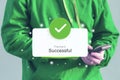 Man holds a smartphone displaying a Payment Successful notification with a green checkmark. Online payment concept