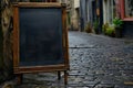 Mockup. Restaurant, cafe, bar sidewalk chalkboard sign board. Antique-looking blackboard, A-board on cobblestone street Royalty Free Stock Photo