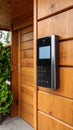 Modern video intercom system mounted on wooden exterior of a home entrance Royalty Free Stock Photo
