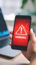 Person Holding Smartphone Showing Warning Sign, Concept of Cyber Security and Data Breach Royalty Free Stock Photo