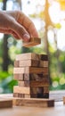 Person placing wooden block on tower game with blurred background Royalty Free Stock Photo