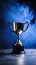 Silver Trophy Cup with Blue Smoke Background on Dark Surface Royalty Free Stock Photo
