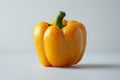 single orange bell pepper sits against white backdrop highlighting its shiny surface and natural shape. Subtle shadows Royalty Free Stock Photo