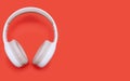 Single white wireless Bluetooth headphones on orange background with free space for text Royalty Free Stock Photo