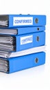 Stack of blue office binders with confirmed labels on white background Royalty Free Stock Photo
