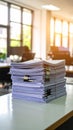 Stack of documents and paperwork on a desk in an office setting with sunlight. Royalty Free Stock Photo