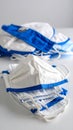 Stack of White and Blue Fabric Face Masks on White Surface Royalty Free Stock Photo