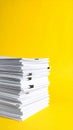 Stack of white paper documents with black clips against a bright yellow background Royalty Free Stock Photo